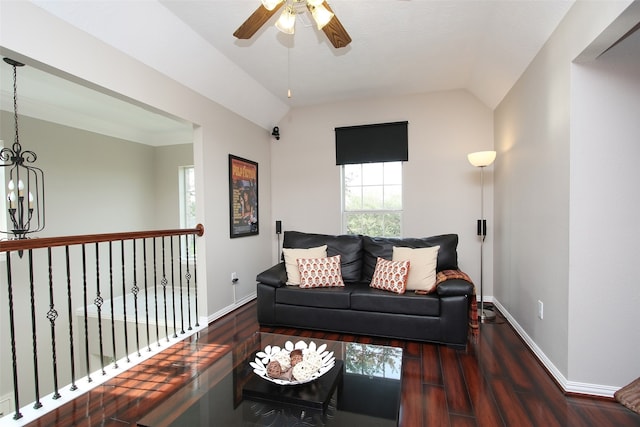 living room with ceiling fan with notable chandelier, dark hardwood / wood-style flooring, and lofted ceiling