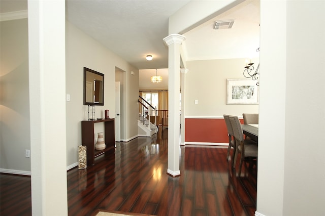 hallway with dark hardwood / wood-style floors and decorative columns