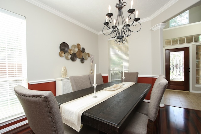 tiled dining area featuring a chandelier, crown molding, and ornate columns