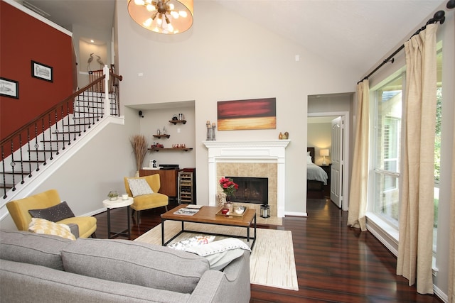 living room with high vaulted ceiling, beverage cooler, dark hardwood / wood-style floors, a fireplace, and a chandelier