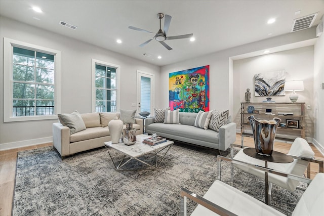 living area featuring baseboards, visible vents, and recessed lighting