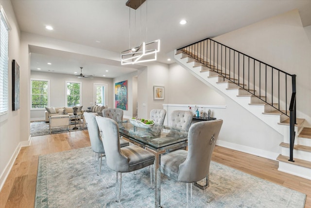 dining room with stairway, light wood-style flooring, and baseboards