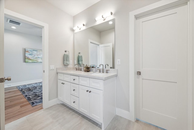 full bathroom featuring visible vents, a sink, baseboards, and double vanity