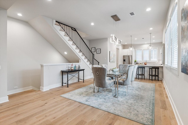 dining area with light wood finished floors, baseboards, visible vents, stairs, and recessed lighting