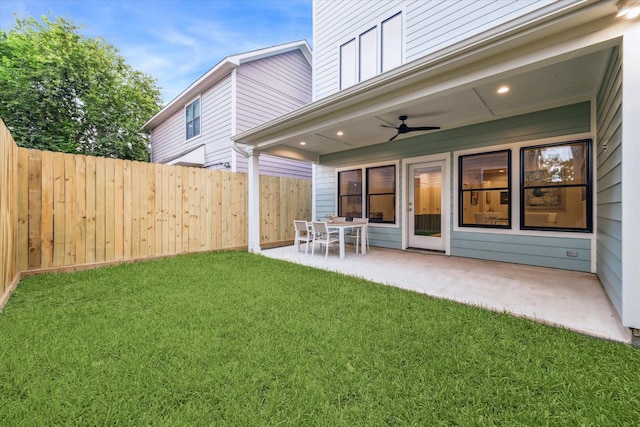 view of yard featuring fence, a ceiling fan, and a patio