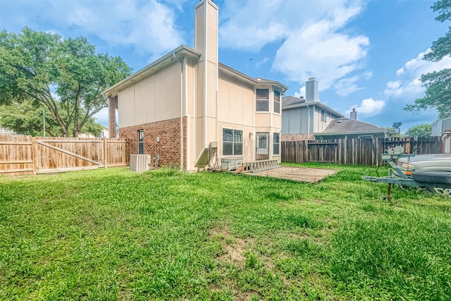 back of property featuring a patio, a yard, and central AC