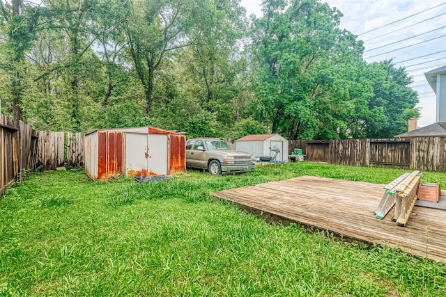 view of yard featuring a deck and a storage shed