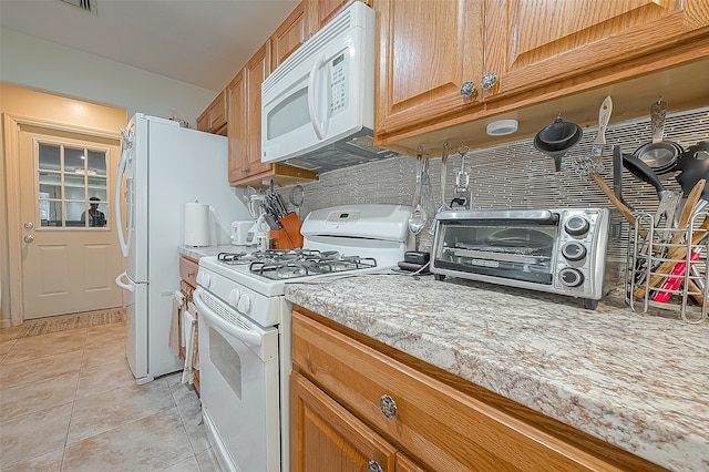 kitchen featuring white appliances and light tile floors