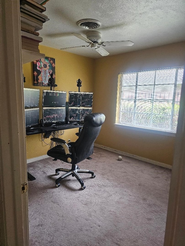 carpeted home office featuring ceiling fan and a textured ceiling