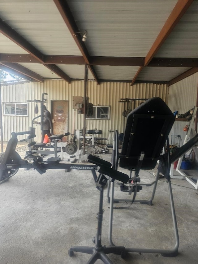 exercise room with concrete floors and lofted ceiling