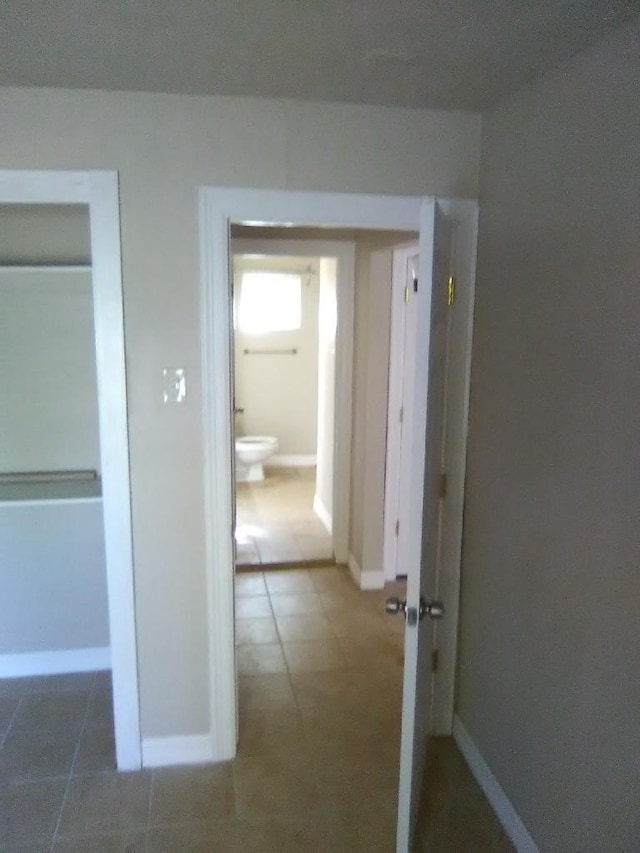 corridor featuring dark tile patterned flooring