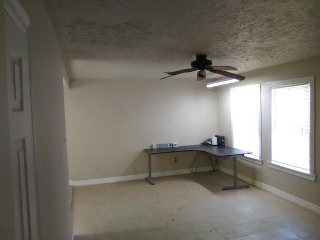 unfurnished office featuring ceiling fan and a textured ceiling