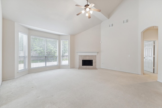 unfurnished living room featuring a fireplace, high vaulted ceiling, ceiling fan, and light carpet