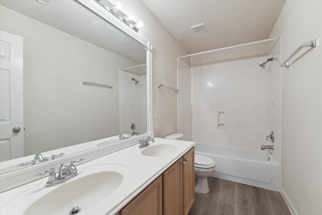 full bathroom with oversized vanity, toilet, shower / bathing tub combination, double sink, and hardwood / wood-style floors