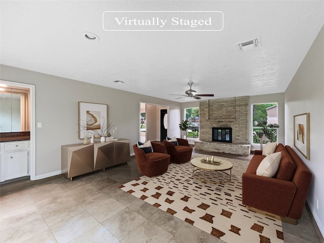 tiled living room with ceiling fan, brick wall, and a brick fireplace