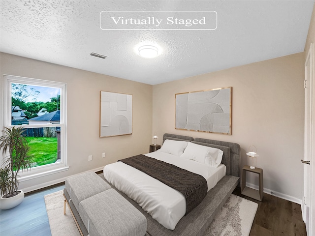 bedroom featuring hardwood / wood-style flooring and a textured ceiling