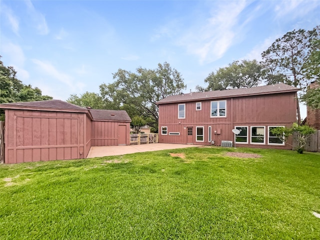 rear view of property with central AC unit, a yard, and a patio area