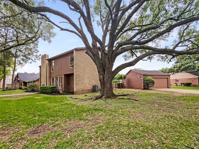 view of front of property featuring a front yard, a garage, and central AC