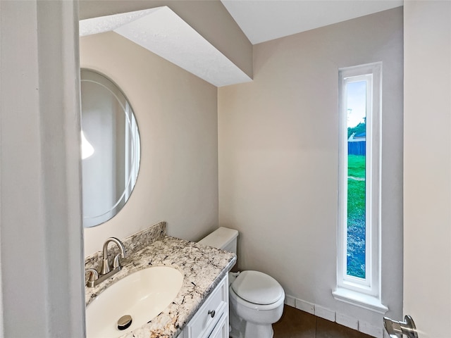 bathroom with toilet, tile floors, and vanity