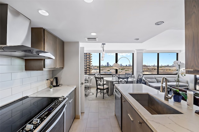 kitchen featuring backsplash, wall chimney exhaust hood, electric range, and a wealth of natural light