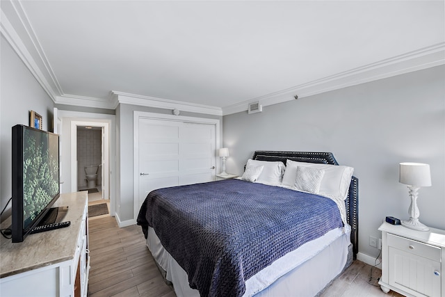 bedroom with a closet, crown molding, and light wood-type flooring