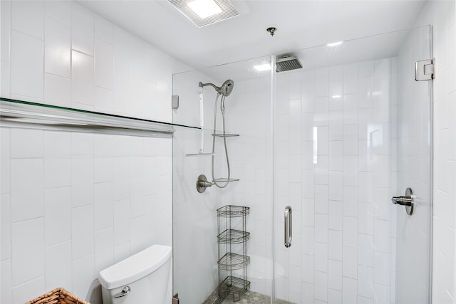 bathroom with a shower with shower door, toilet, and tile walls