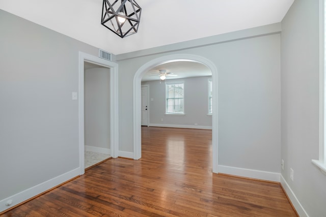 unfurnished room with dark hardwood / wood-style flooring and ceiling fan