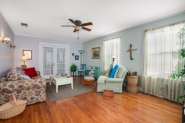 living room featuring plenty of natural light, ceiling fan, and light wood-type flooring