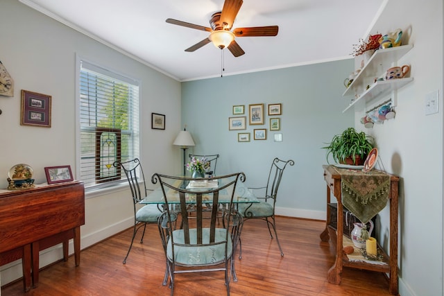 dining area with ornamental molding, wood-type flooring, and ceiling fan