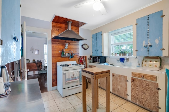 kitchen featuring white range with gas cooktop, crown molding, light tile floors, range hood, and ceiling fan