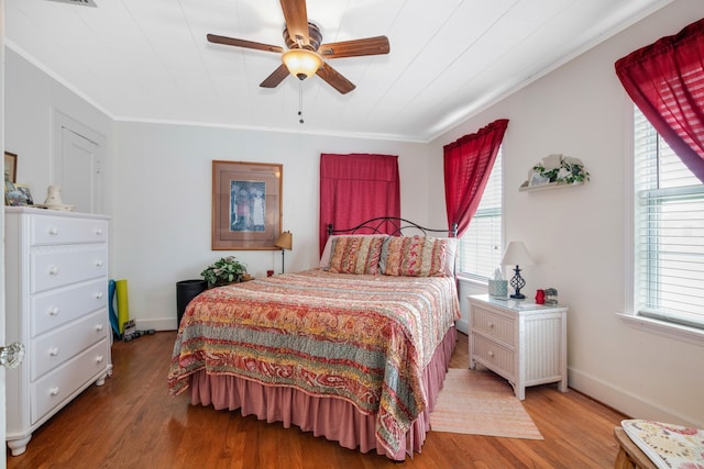 bedroom featuring ceiling fan, crown molding, and hardwood / wood-style flooring