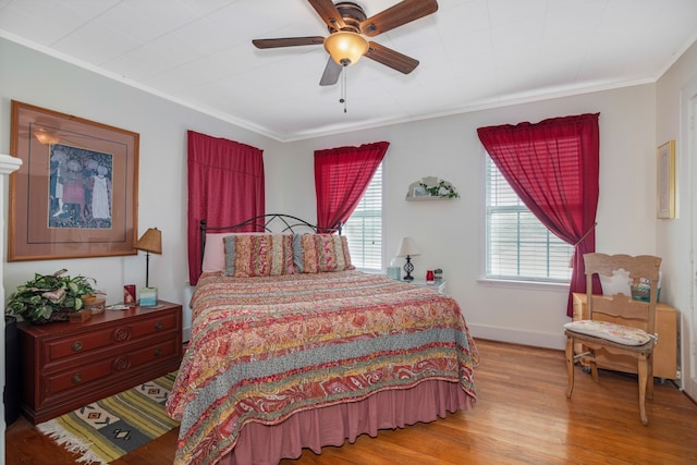 bedroom featuring ornamental molding, wood-type flooring, and ceiling fan