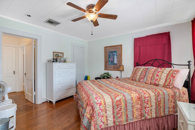 bedroom with ornamental molding, ceiling fan, and dark hardwood / wood-style floors