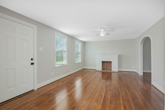 unfurnished living room featuring ceiling fan, a fireplace, and dark hardwood / wood-style floors