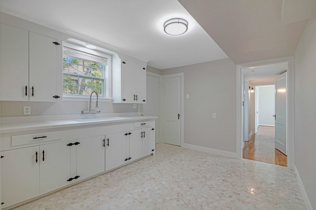 kitchen with white cabinets, light hardwood / wood-style flooring, and sink