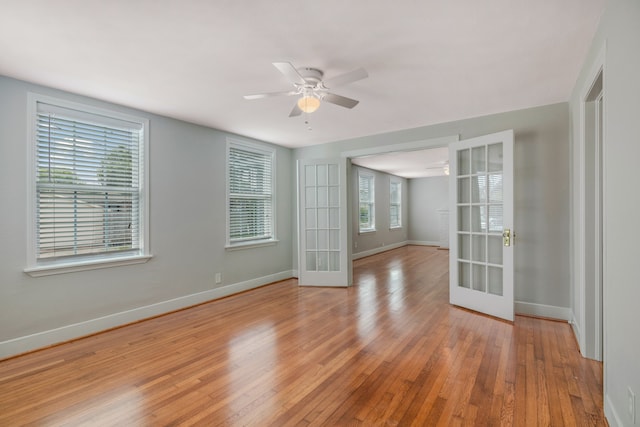 spare room featuring french doors, ceiling fan, and light wood-type flooring