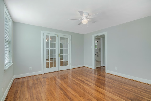 spare room featuring hardwood / wood-style floors, ceiling fan, and french doors