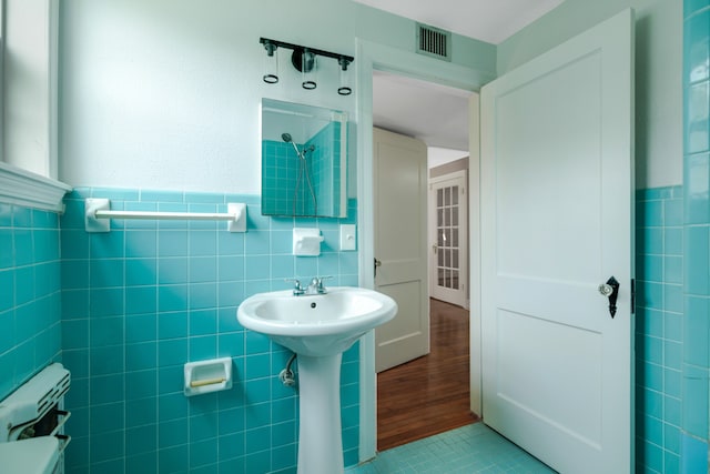 bathroom with tile walls, toilet, backsplash, and tile flooring