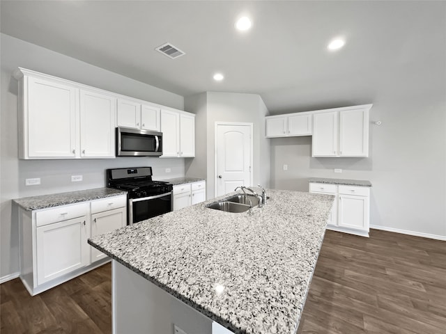 kitchen featuring sink, a kitchen island with sink, stainless steel appliances, and dark wood-type flooring