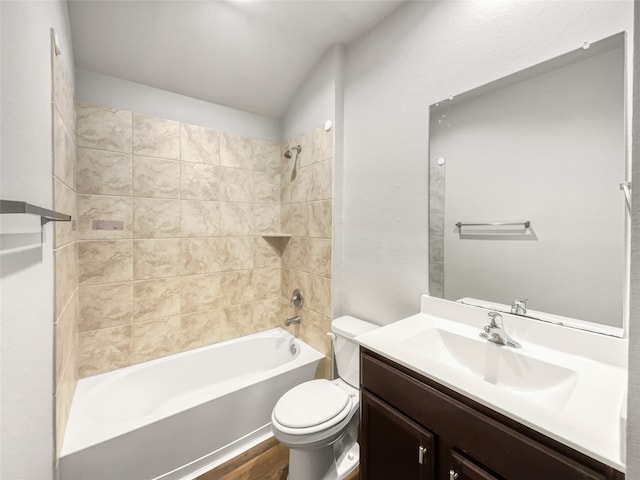 full bathroom featuring hardwood / wood-style flooring, tiled shower / bath combo, toilet, and vanity