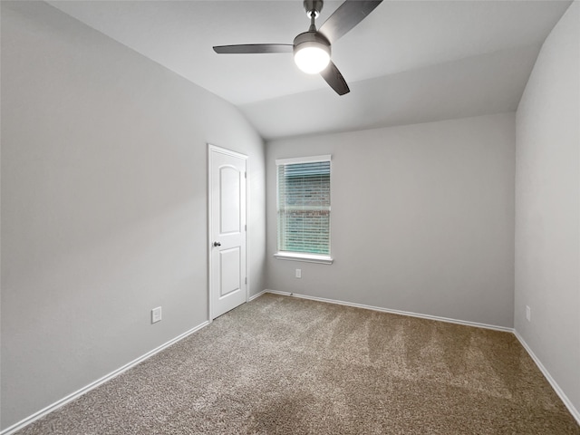 carpeted empty room featuring vaulted ceiling and ceiling fan