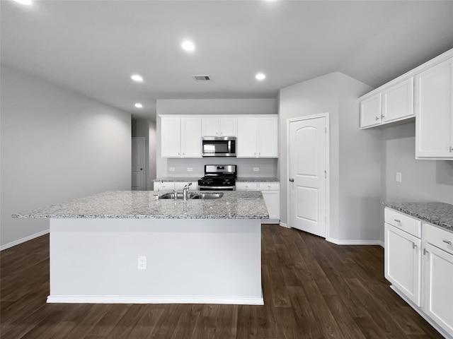 kitchen featuring appliances with stainless steel finishes, dark hardwood / wood-style floors, a kitchen island with sink, light stone counters, and white cabinets