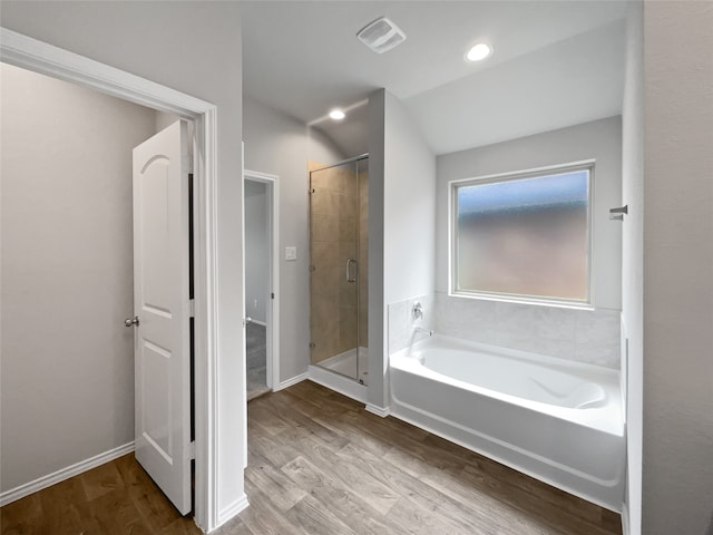 bathroom with hardwood / wood-style flooring and shower with separate bathtub