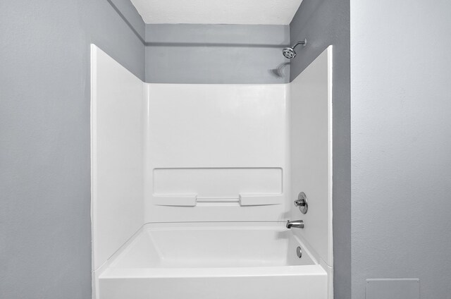 bathroom featuring a textured ceiling and  shower combination