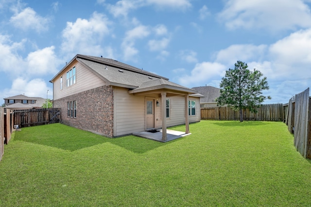 rear view of property with a patio and a yard