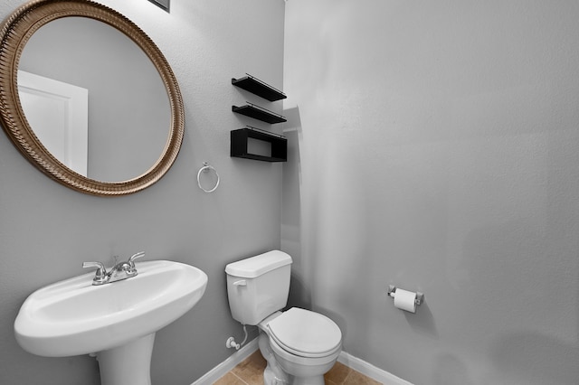 bathroom featuring tile floors, sink, and toilet