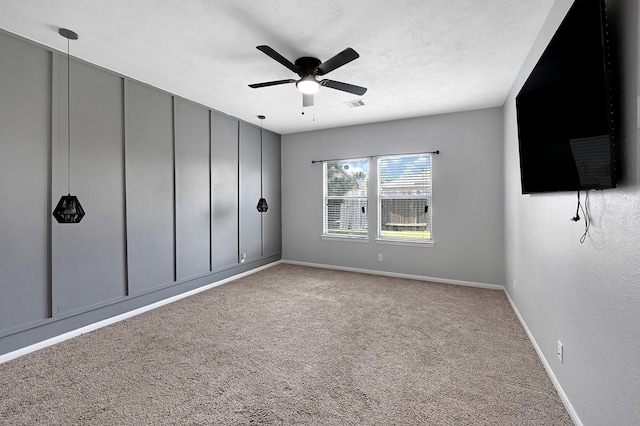 carpeted empty room featuring ceiling fan