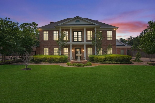 neoclassical / greek revival house featuring a yard