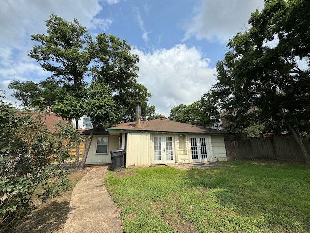 view of front of home with a front yard and french doors