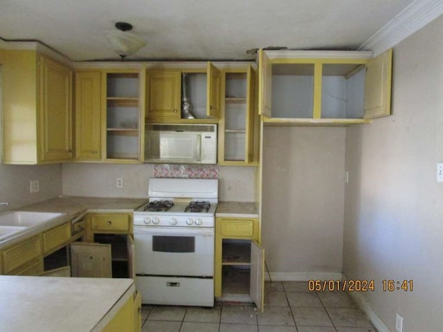 kitchen with sink, crown molding, white appliances, and light tile floors